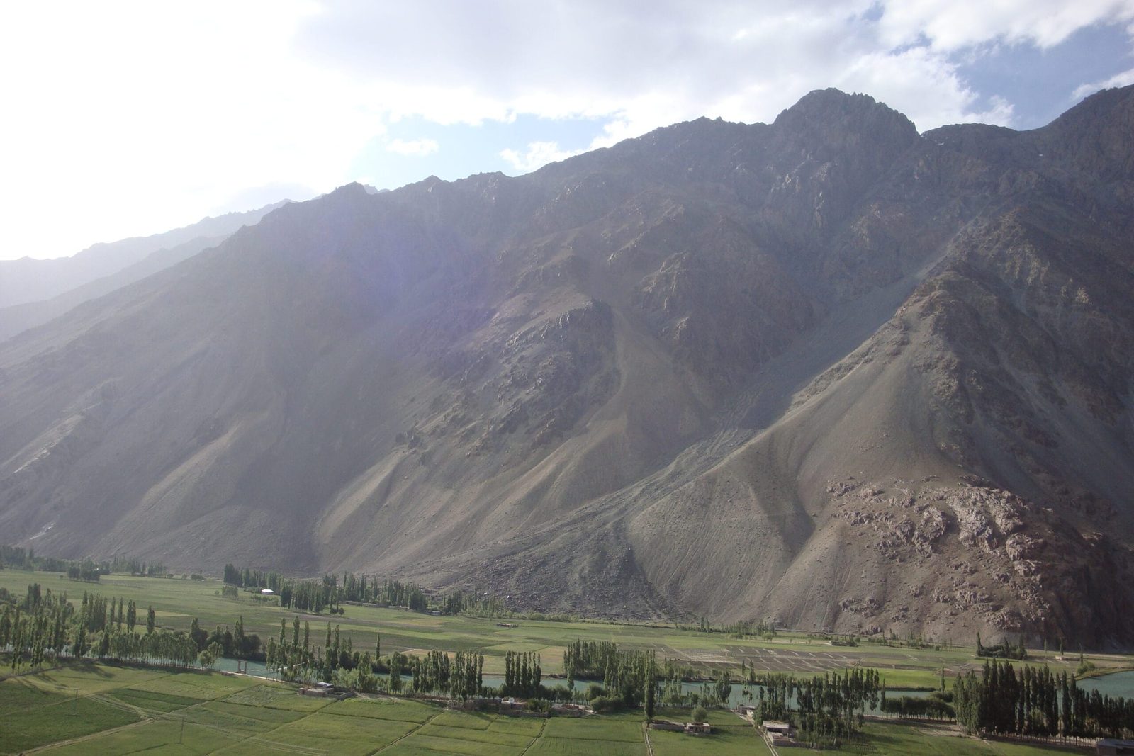Phander Valley lake surrounded by green fields and mountains in Ghizer, Gilgit-Baltistan