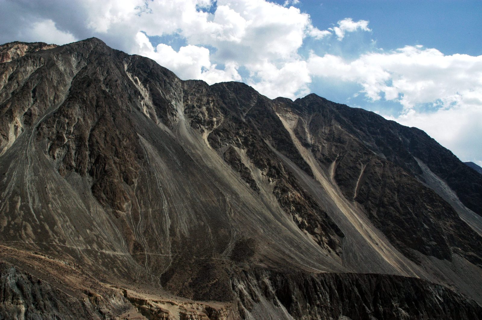 Steile Bergflanken und ein Schwemmfächer umschließen das Bagrot-Tal bei Gilgit, Pakistan