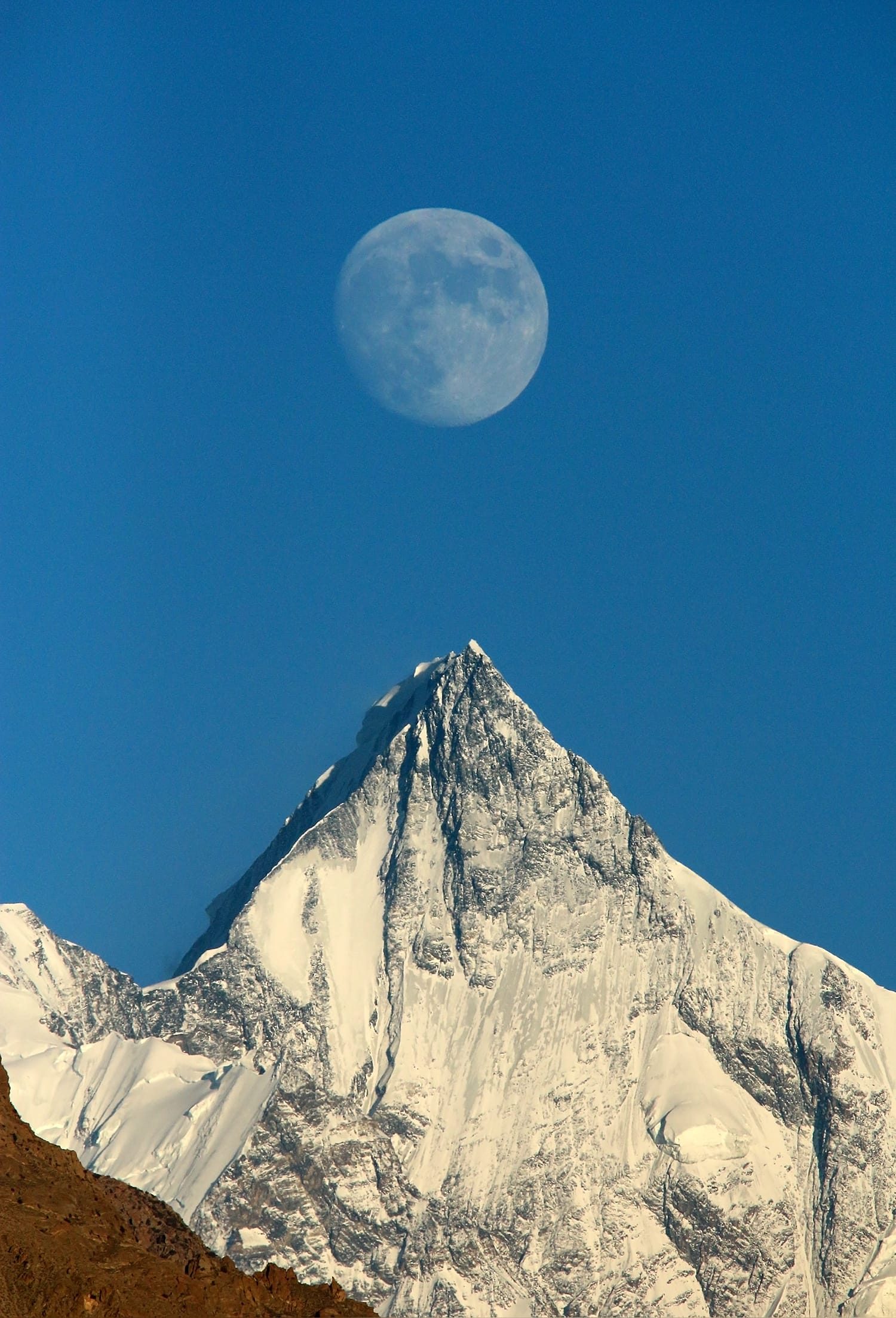 Der Mond geht über dem Schneegipfel des Lupghar Sar auf, gesehen von Aliabad in Hunza